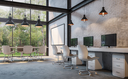 modern office with concrete flooring, white office chairs, and exposed white brick wall and window wall