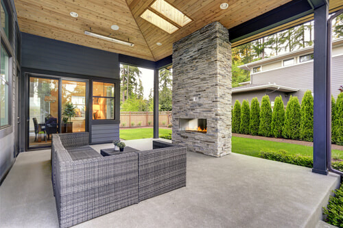 backyard concrete patio with seating and a fireplace